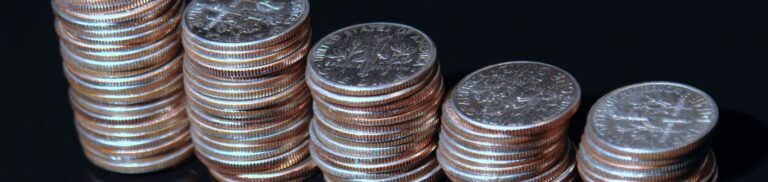 Close-up view of a pile of shiny US dime coins, emphasizing their reflective surfaces and stacked arrangement.