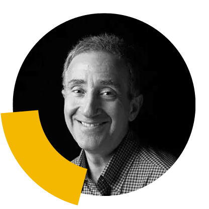 Douglas Winter smiling, wearing a checkered shirt, with a yellow graphic element in the foreground.