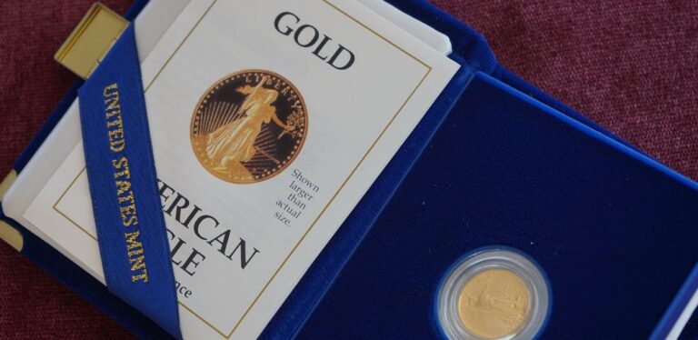 Gold American Eagle coin in a blue display case with a booklet titled "Gold" from the United States Mint.