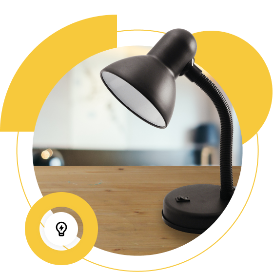 A black desk lamp with a flexible neck is positioned on a wooden surface, with a blurred background.